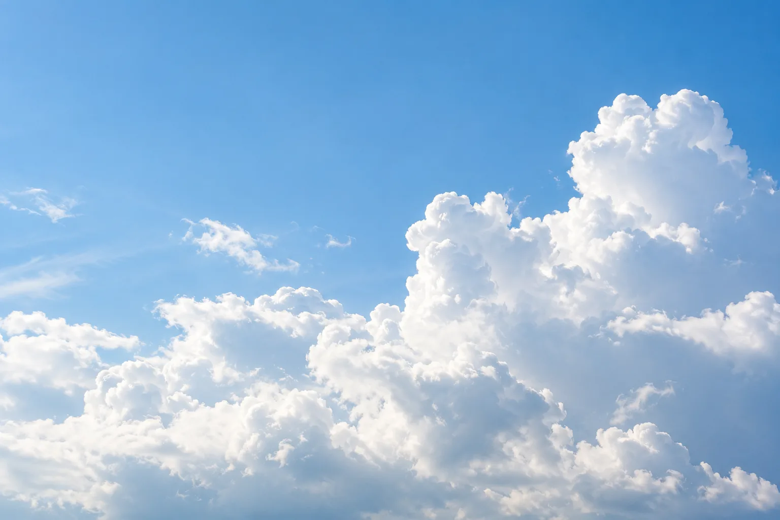 Illustrative white cumulus clouds in a clear blue tropical sky